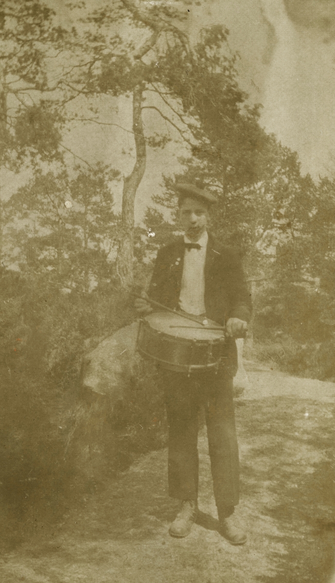 Portrettfotografi av en ung mann på en sti med trommer.