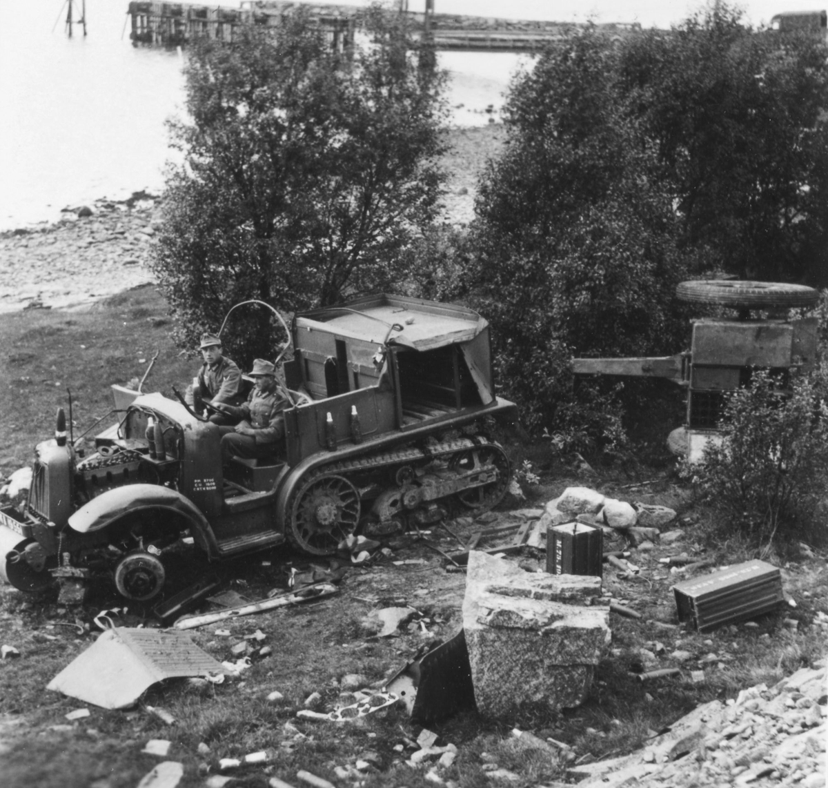 To tyske soldater i en ødelagt halvbeltevogn.