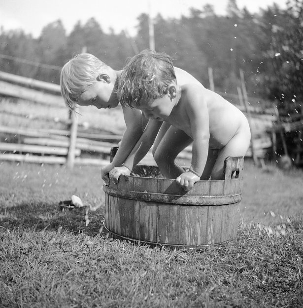 Barn (2) som badar i en balja.