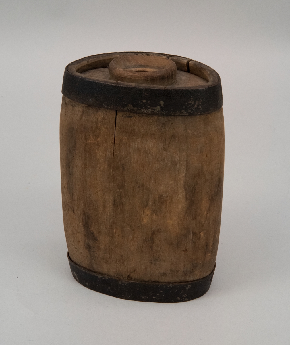 Drickvattenbehållare eller flaska, av gråbrunt trä med förstärkande metallband upptill och nertill.