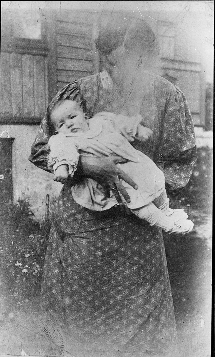 Ukjent kvinne med spedbarn på armen. Ca. 1900.