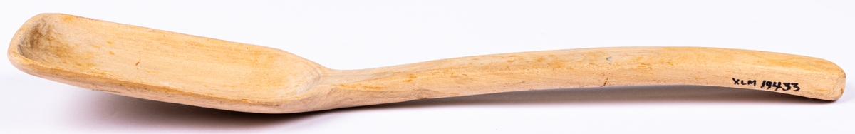 Acc.kat: Slev. Trä, omålad. Raka kanter på tre sidor av skedskålen. På baksidan ett ritat ansikte i blyerts och färgpenna. Skaftet märkt "3421/-50".