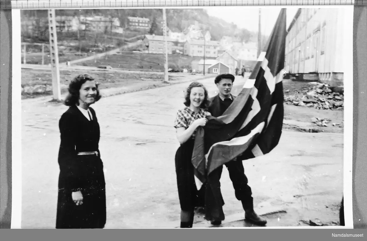 Namsos sentrum, mai 1945. Flagget heises på Namsos E-verks brakke.