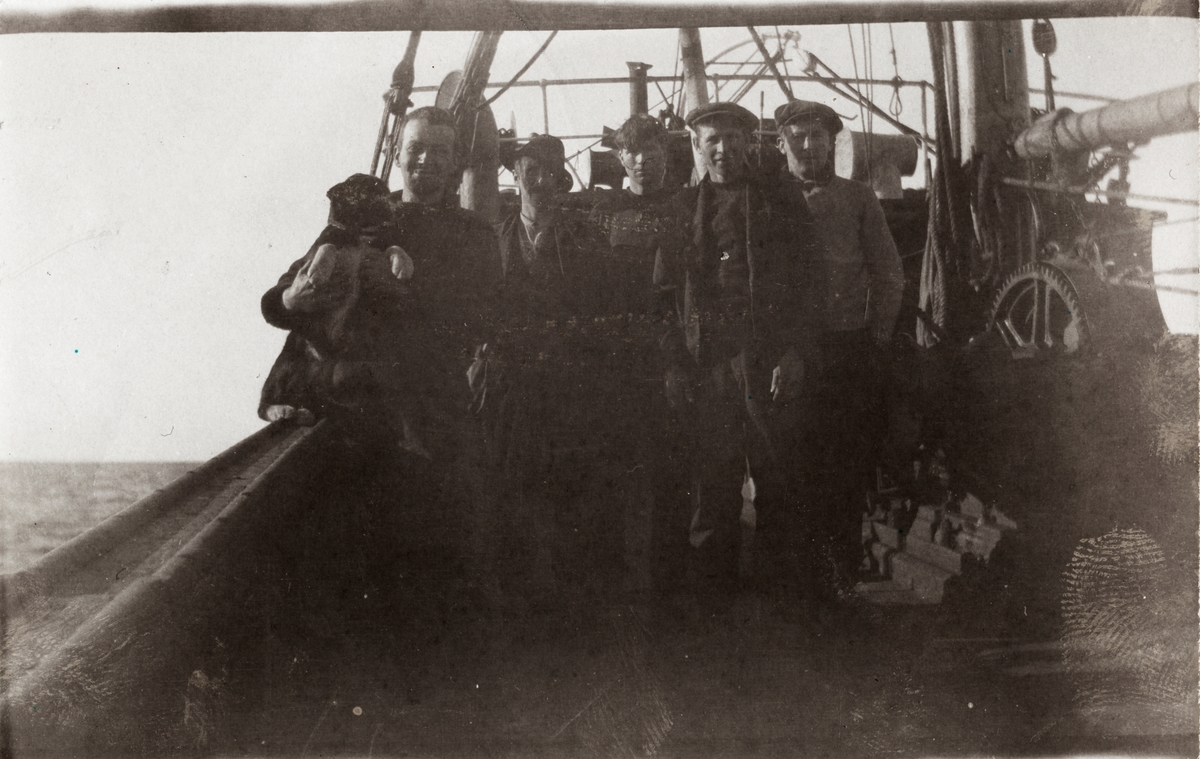 Gruppeportrett av menn ombord i ei ishavsskute.