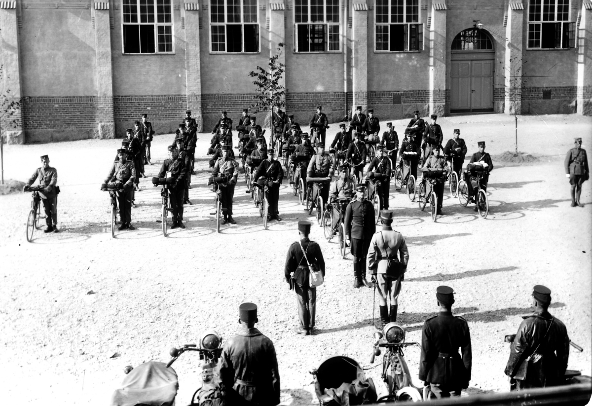 IV. Fördelningens Velocipedordonnansskola år 1923

Löjtnant Bertil Hökerberg lämnar av till kompanichefen, kapten George Murray.

Truppen uppställda framför gymnastiksalen (By 9), vända mot kasern 7.