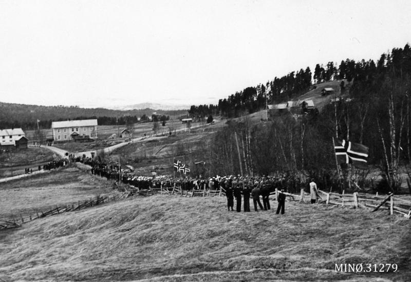 17. mai 1945 i Os. Toget på vei fra skolen og opp mot kirka. Fremst i toget gikk medlemmer av Heimestyrkene. Foto: Musea i Nord-Østerdalen, nr. 31279. (Foto/Photo)
