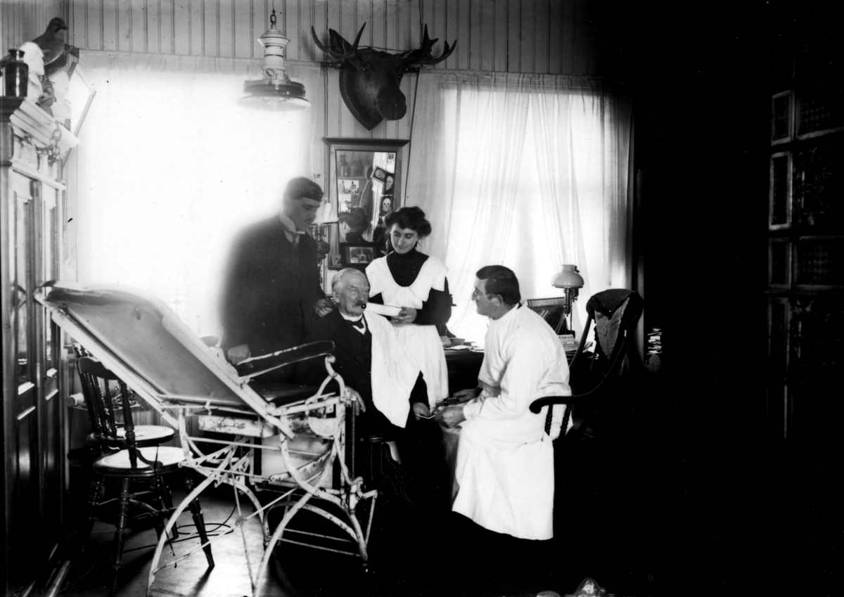 Doktor Otto Mejlænder med to menn og en kvinne på legekontor i Trysil.
