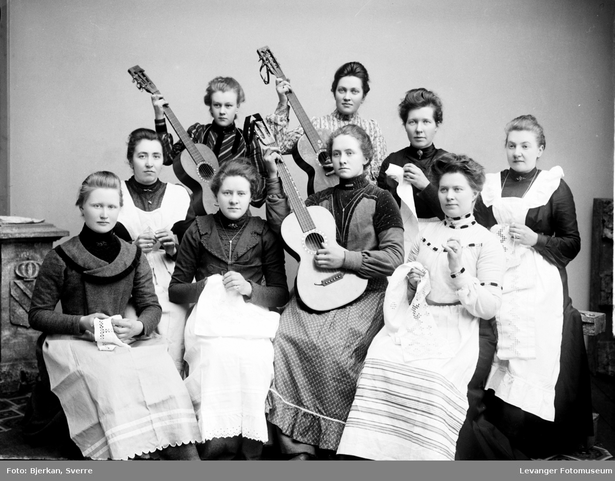 Gruppebilde av kvinner med gitarer og broderier av typen hardangersøm. Skolebilde/kurs?