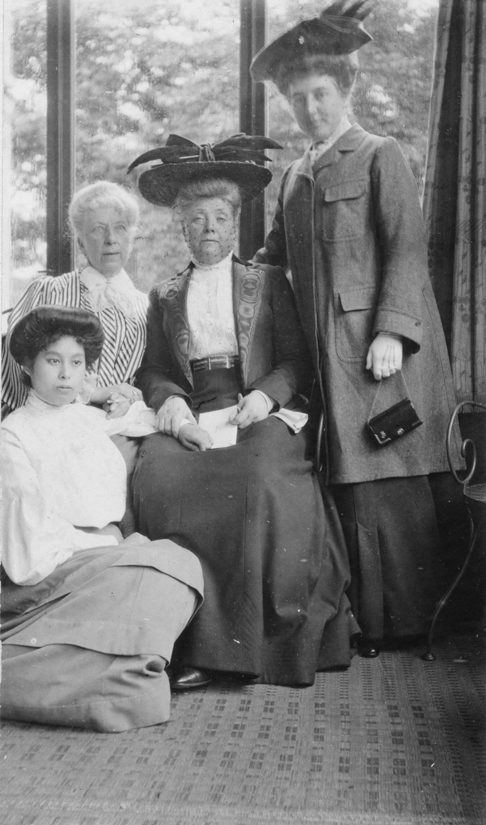 Antonie Rettig sittandes i mitten, tillsammans med sin syster Sophie von Plessen till vänster samt två okända kvinnor, sannolikt på veranda vid Villa Rettig, Gävle.