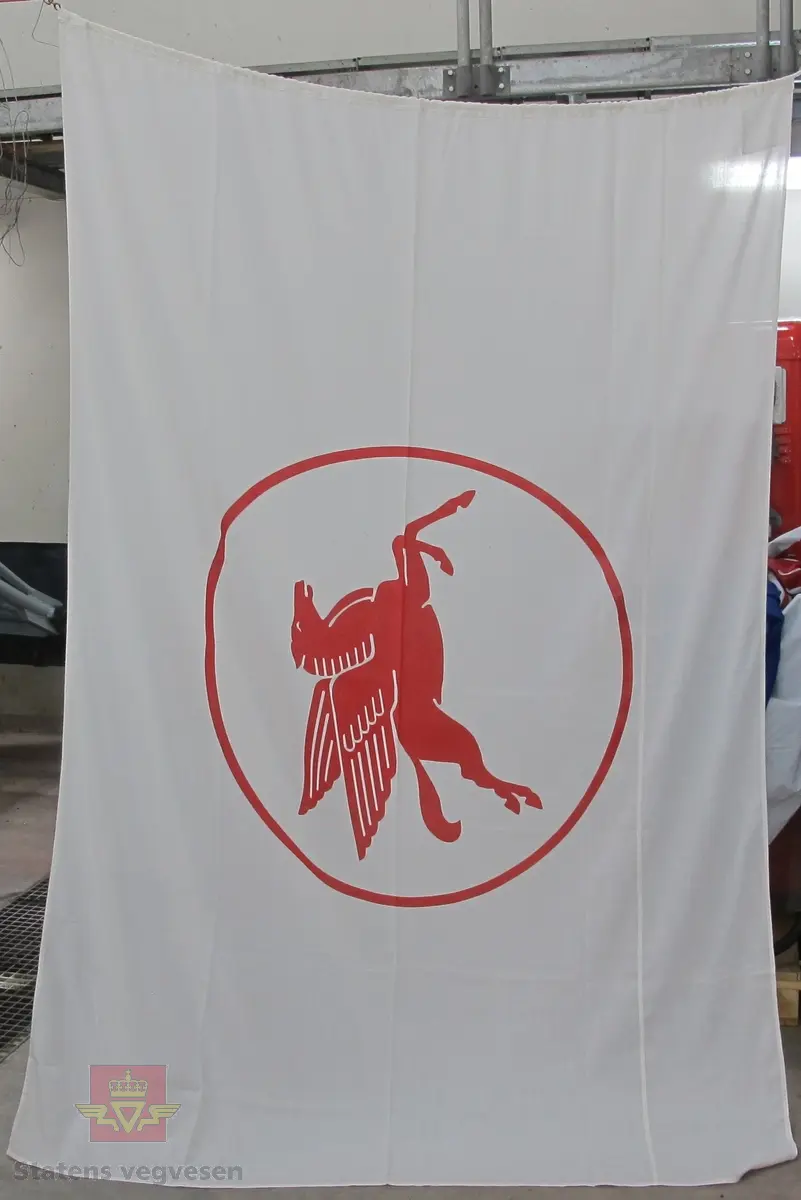 Rektangulært flagg i tekstil med tau og to opphengskroker i metall. Hvitt med rød Pegasus med ring rundt. Opphengstauet er hvitt, og krokene har gullfarge.