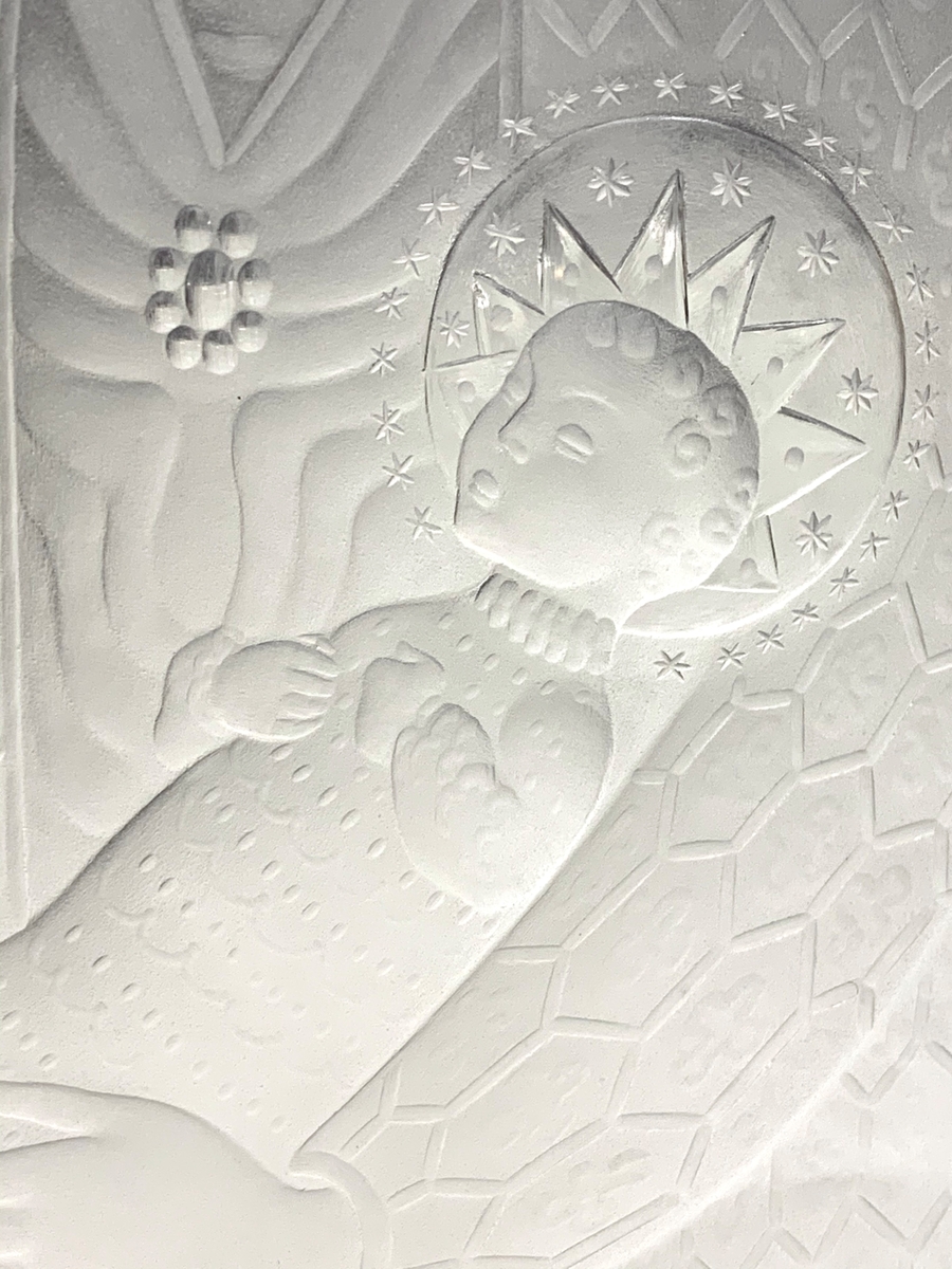 "Madonnan" av Sven Palmqvist. Platt och hög vas med graverat motiv av Maria som sitter i en katedral med Jesus i famnen. Formgiven av Sven Palmqvist och graverad av Ove Bjerding.
