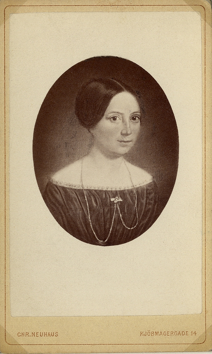 Porträttfoto av en kvinna i klänning (1830-tal ?) med halskedja, brosch m.m.
Bröstbild, halvprofil.

Foto efter målning.