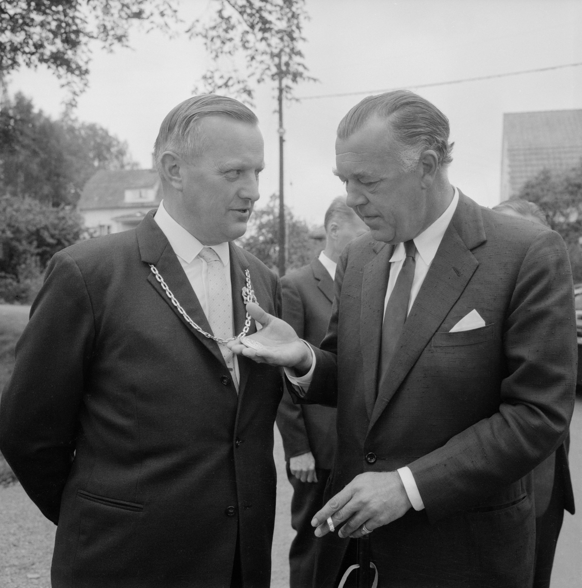 En till synes imponerad prins Bertil granskar borgmästarkedjan runt kommunalfullmäktigeordförande Lennart Eks hals. Ett ögonblick från Åtvidabergs 550-årsjubileum 1963.
