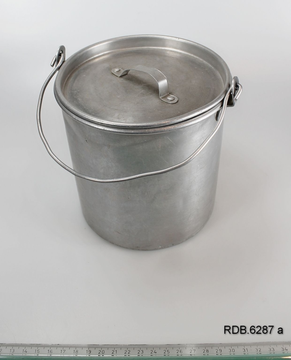 Et sølvfarget, sylindrisk 1-liters aluminiumsspann med hengslet hank og løst lokk med håndtak.