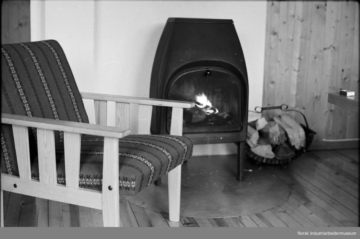 Interiør hytte Frøystul Feriested. En vedovn og lenestol.