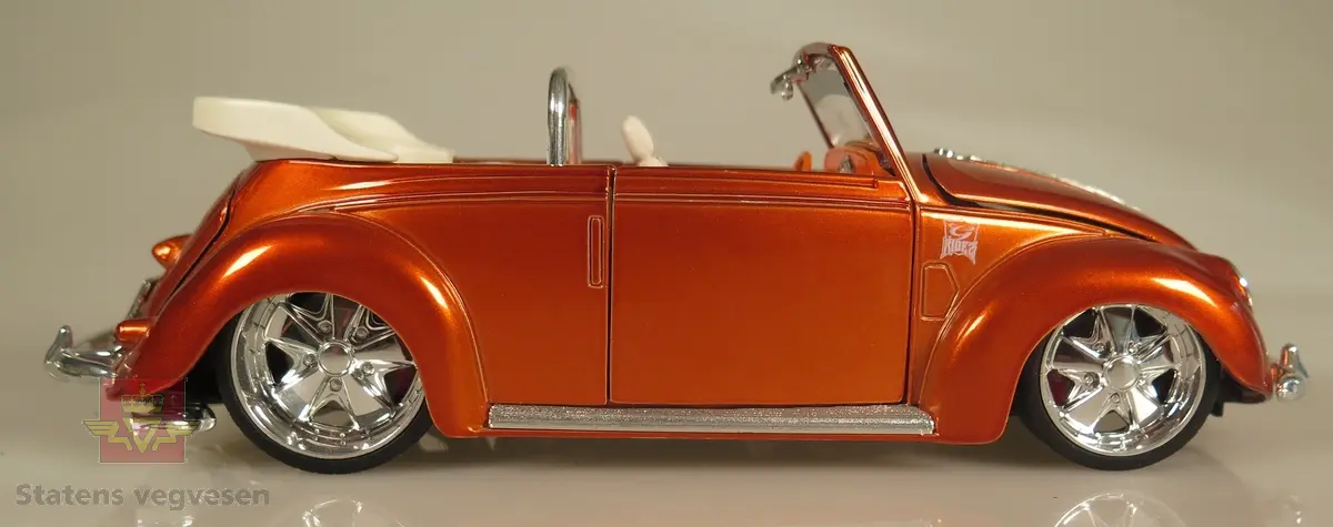 Primært oransje modellbil laget av metall og er detaljert. Den er høyt detaljert og utstyrt med dører, panser og bagasjerom som kan åpnes og lukkes. Skala: 1:18