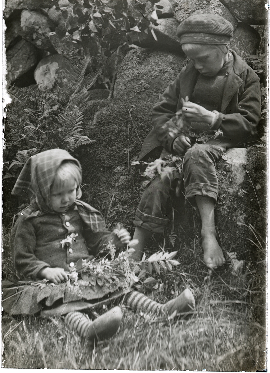 Två barn vid en stenmur.