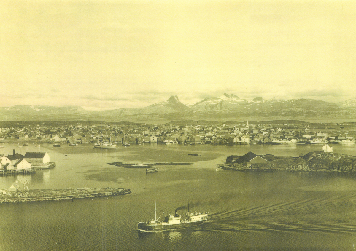 Bodø mellom 1920 og 1940. I forgrunnen er et skip fra Vesteraalens Dampskibsselskab på vei ut. I  bakgrunnen, lenger inn, ligger flere mindre båter, et frakteskip og ei hurtigrute. Skipet i forgrunnen kan være DS Røst, bygd i 1898.