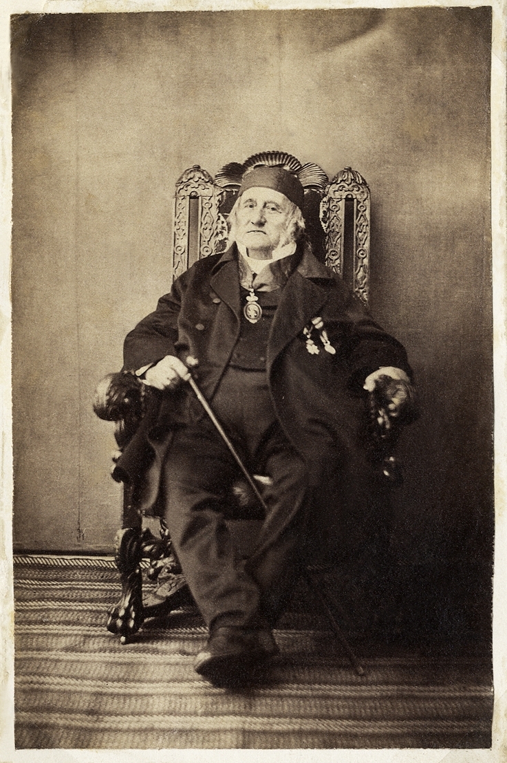 En äldre man i kostym och kalott sitter i en högryggad länstol.
Major Thure Gabriel Gyllenkrok, ateljéfoto.