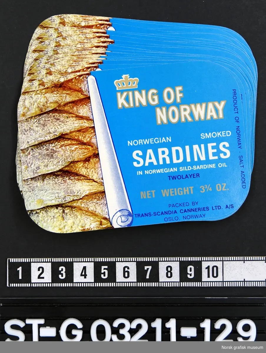 39 etiketter som på høyre side har tekst på lys blå bakgrunn, og på venstre side skimtes innholdet i boksen (fisk) ved at den blå er "rullet" til side. 

"Norwegian smoked sardines in Norwegian sild-sardine oil"