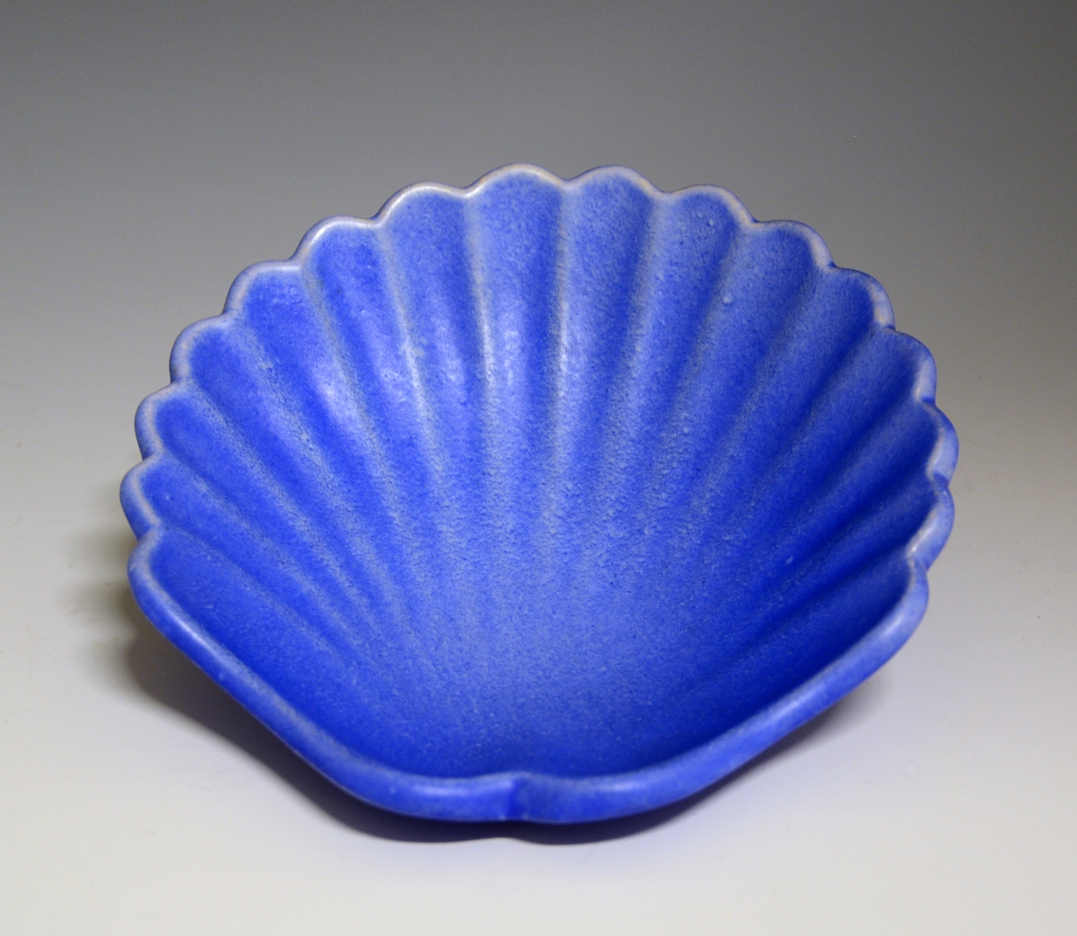 Prot: Skål av "keramikk" formet som et skjell. Blå glasur.

Modell: 5061 
Dekor: 1032