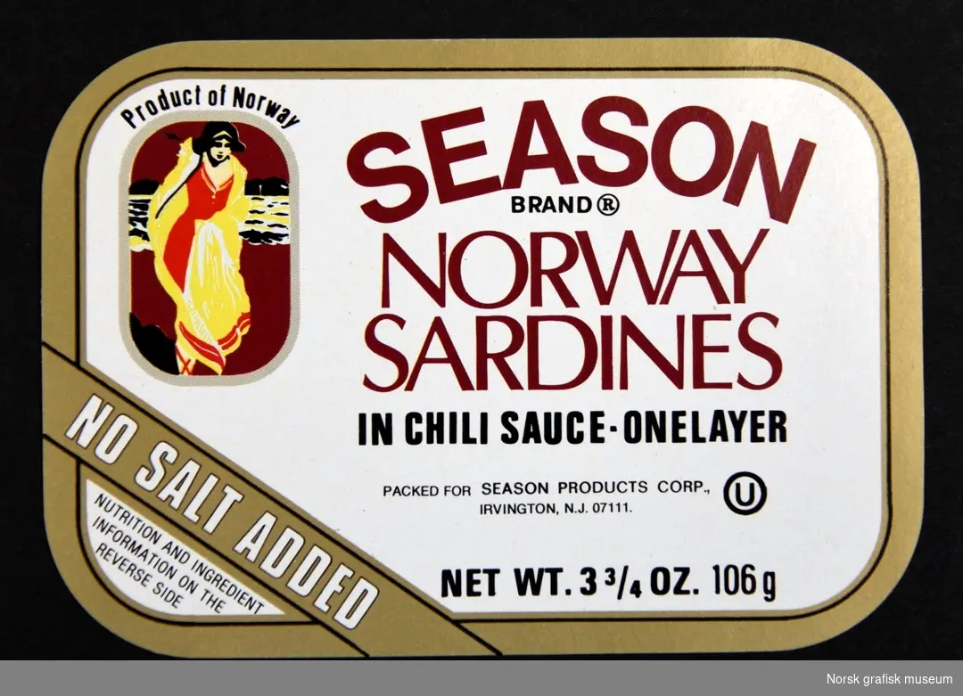 Etikett med hvit bakgrunn og gull ramme. TIl ventre er en illustrasjon av en kvinne på stranden (?). 

"Norway sardines in chili sauce"
