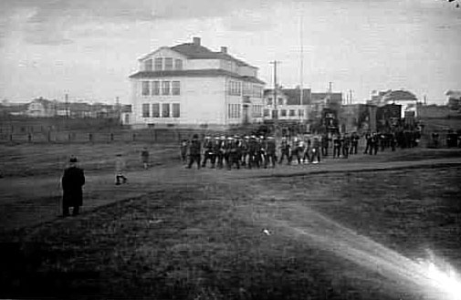 Stationskarl Erikssons begravningsprocession med standar i teten passerar Töreboda skola 1926. 
I teten en blåsorkester under ledning av Fritz Haage.