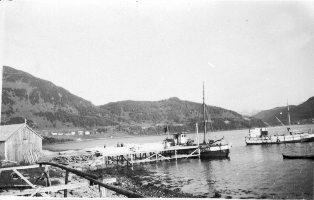 Brygge, kai og båter utenfor Haugland Trelast ved Gårasjøen. Fiskehjell i forgrunnen.