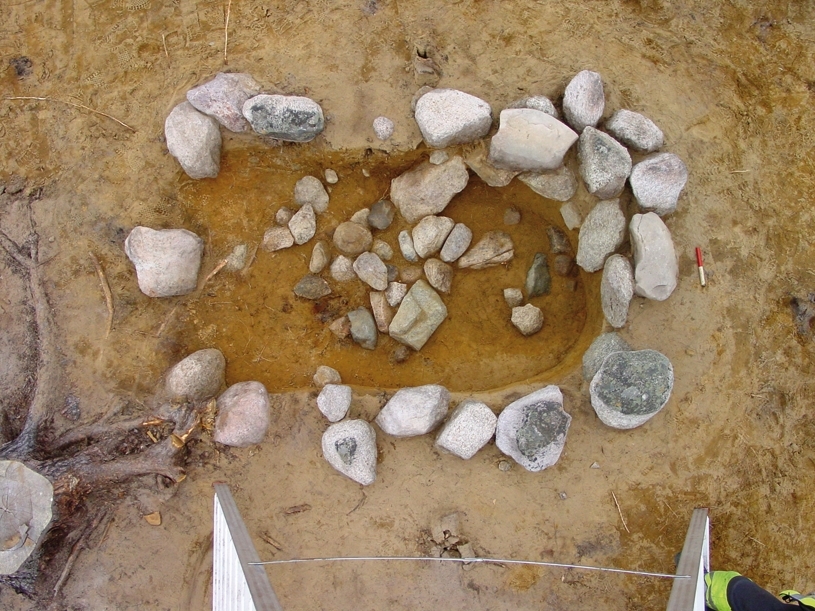 De olika undersökningsmomenten av skelettgraven A9 på gravfältet RAÄ Barnarp 22, L1974:2431 på Torsvik i Jönköping. I botten framkom fynd i form av en kniv, en nål, två bronsringar, keramik samt ett oidentifierat järnföremål. Av skelettet återstod dock ingenting.