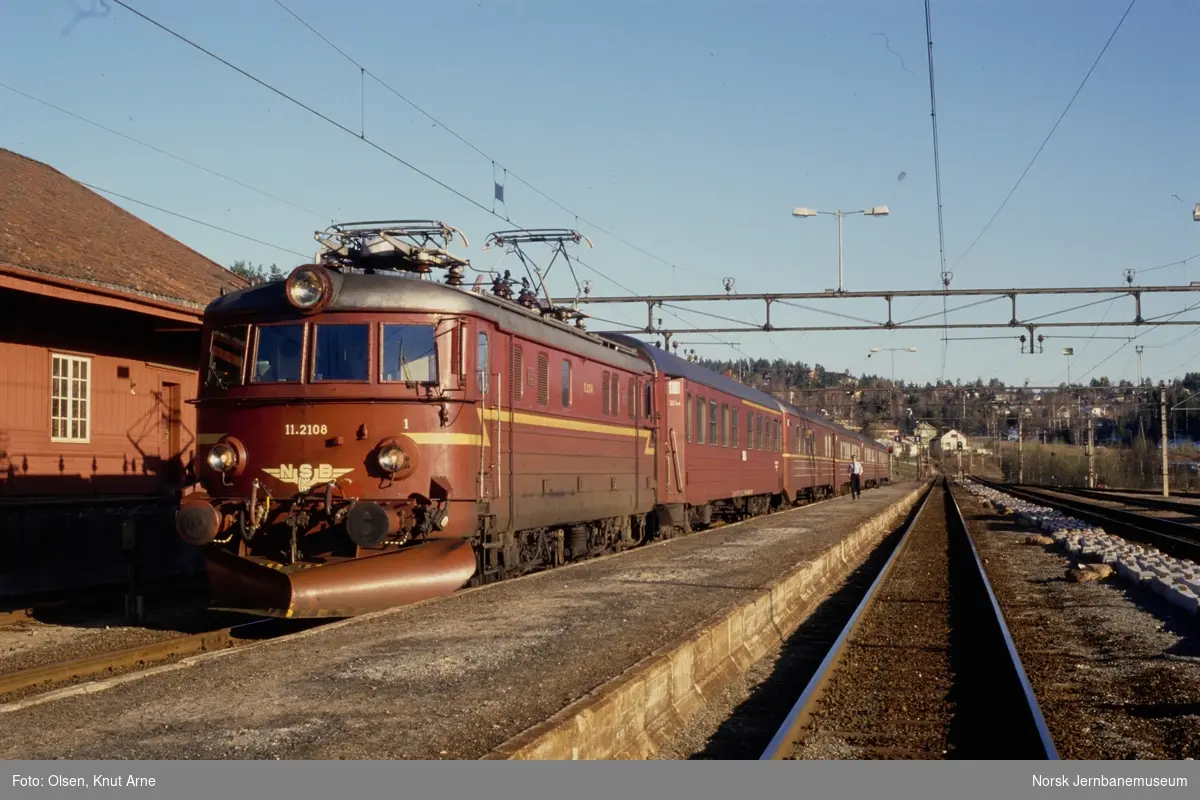 Elektrisk lokomotiv El 11 2108 med ekspresstog til Oslo på Lunde stasjon. Toget avventer kryssing