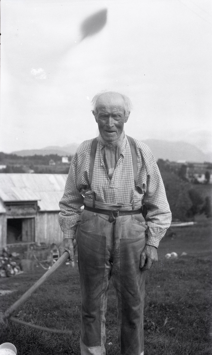 Portrettfotografi av en eldre mann med ljå.
