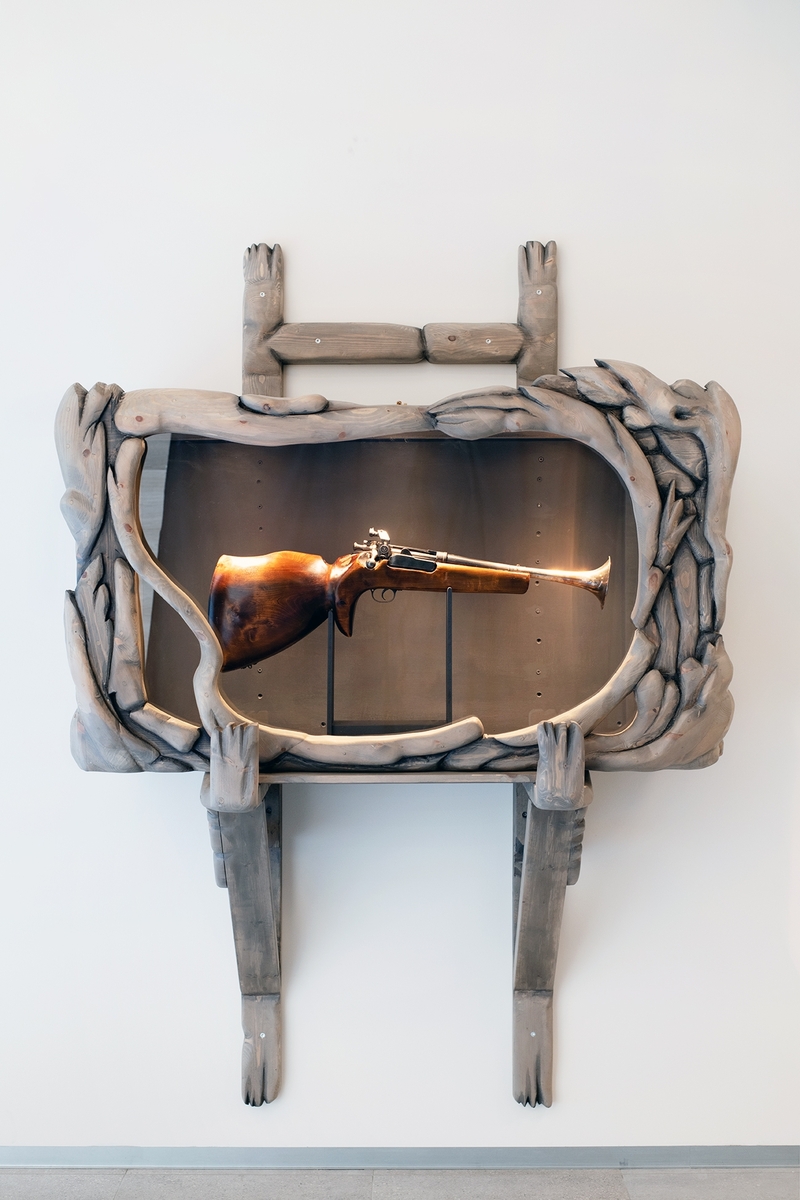 Et skulpturelt våpenskap laget i furu. Illudert som drivved.
Huser Lars Kroff Loftus verk "Store Norske".