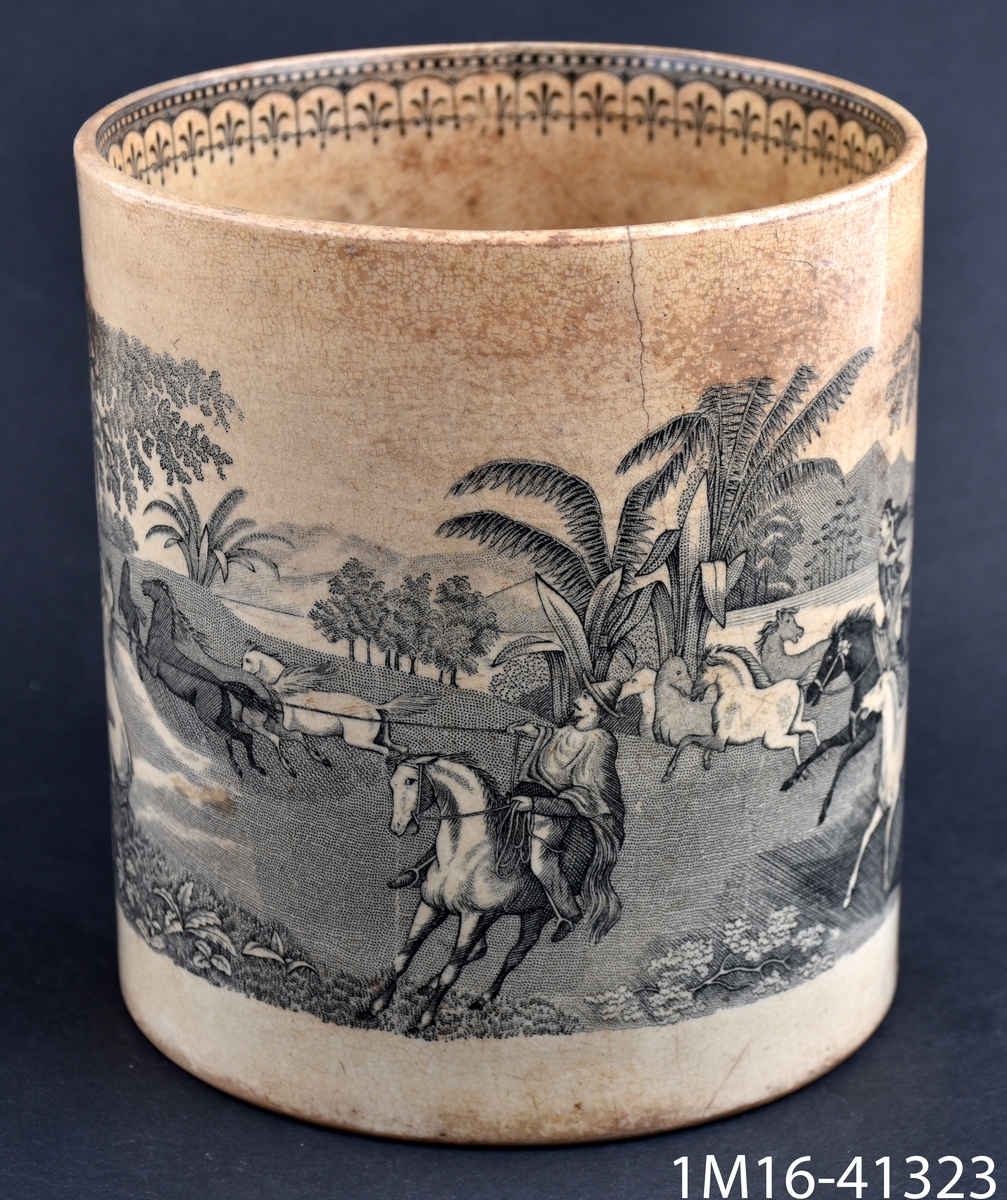 Mugg med motiv: landskap med springande hästar och två ryttare med lasso. Bårddekor på handtaget och insidan på överkant.