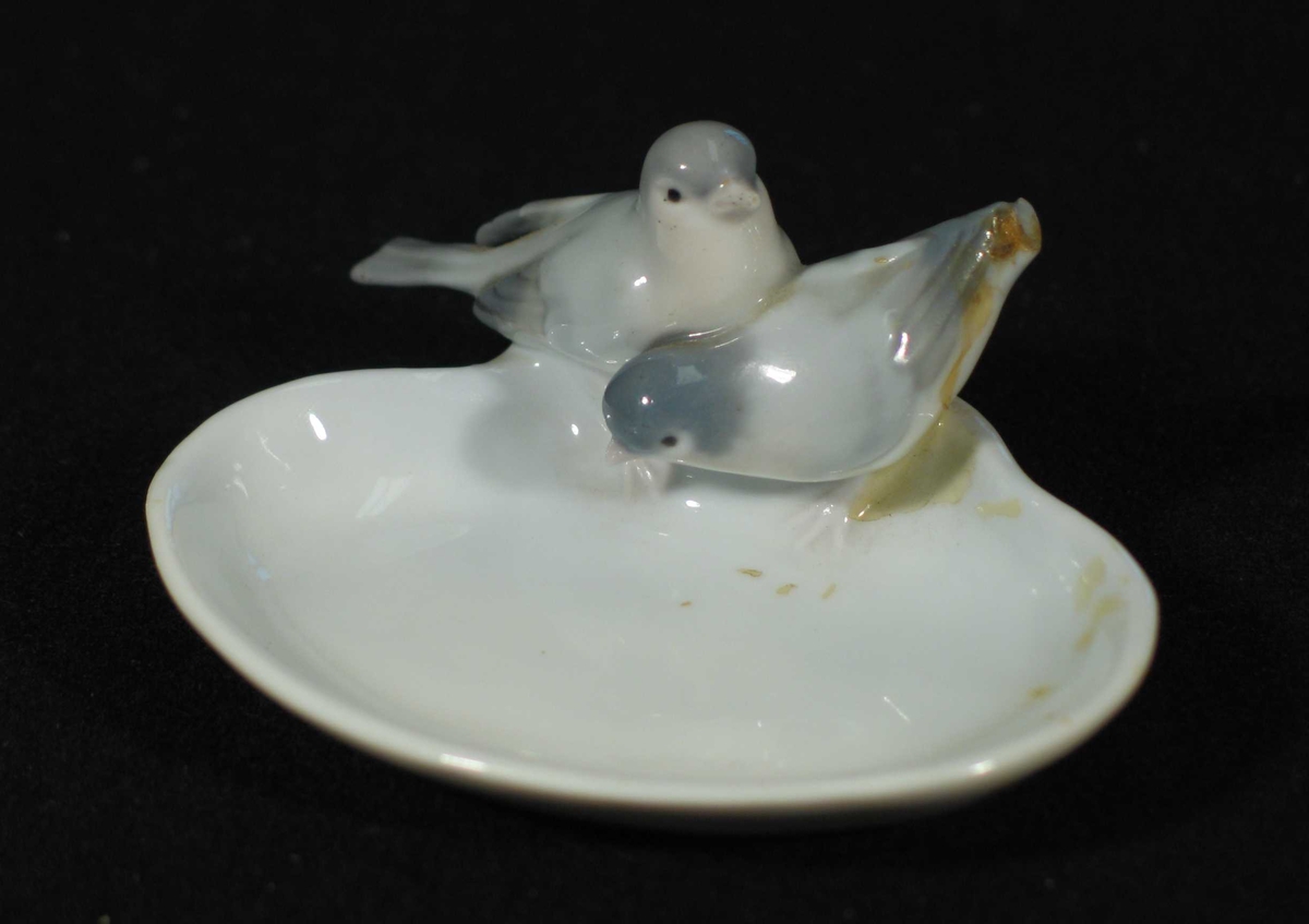 Oval skål i porselen med to fugler på langsiden.