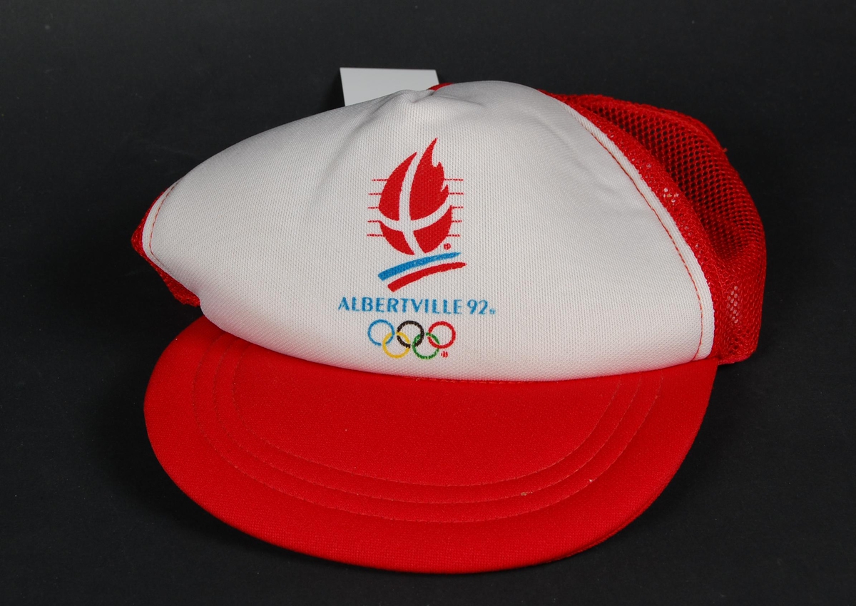 Rød og hvit skyggelue med logo for de olympiske vinterleker i Albertville i 1992. Strammespennen av plast er ødelagt.