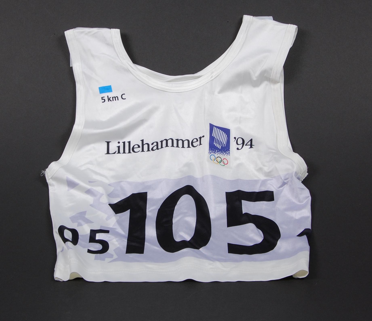 Startnummer med logoer for de olympiske vinterleker på Lillehammer i 1994 og krystallmønster. Krystallmønsteret inngikk i LOOCs designprogram. 
