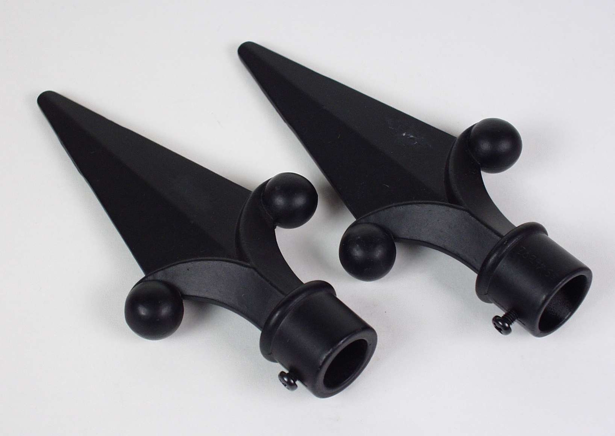 To endestykker til gardinstang. De er laget i svartlakkert metall og formet som spyd.