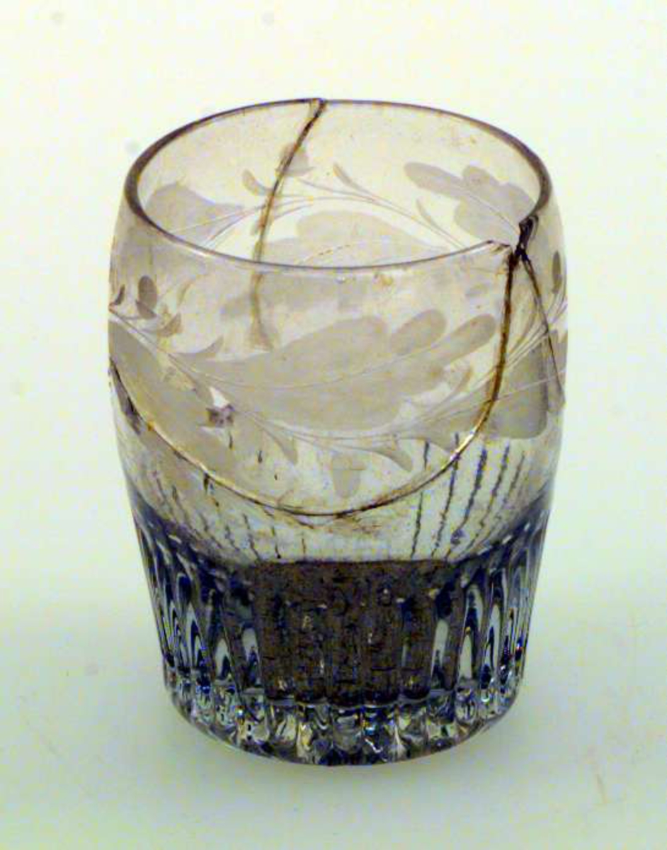 Lett buet glass med ekeløvdekor og fasseterte sider. Glasset er limt og biter av glasset mangler.