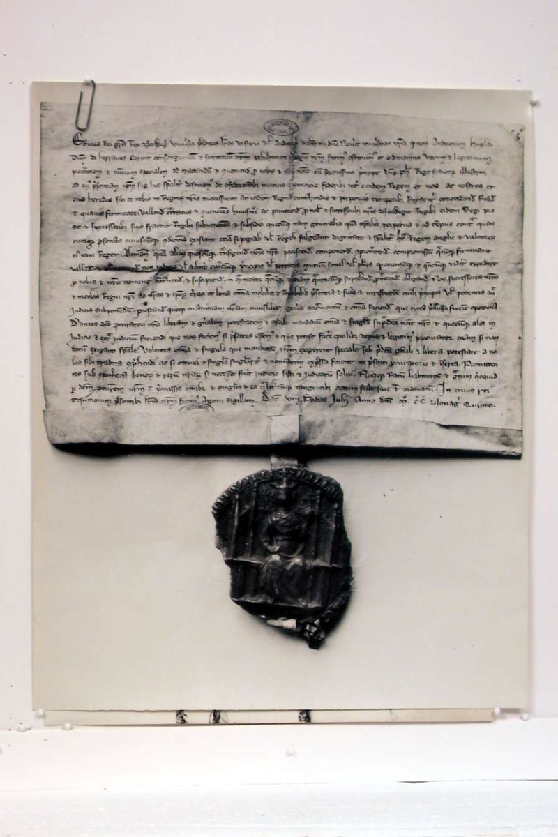 Pappomslag som inneholder 2 sort/hvite fotografier av historiske tekster og et brev.