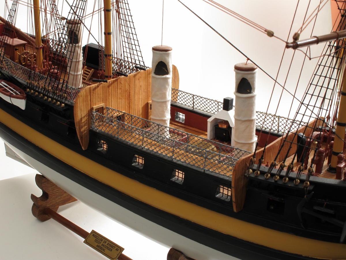 Modell av handelsfregatt og slaveskip Fredensborg, bygd etter skutebilde og studier av skipstypen. Skipet har tre master, rær på alle.  Alle deler er laget av modellbyggeren.