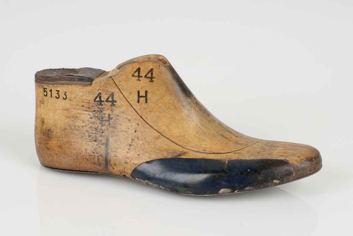 En tremodell; hengslet lest
Høyrefot i skostørrelse 44.
Lestekam av skinn.
Såle av metall
