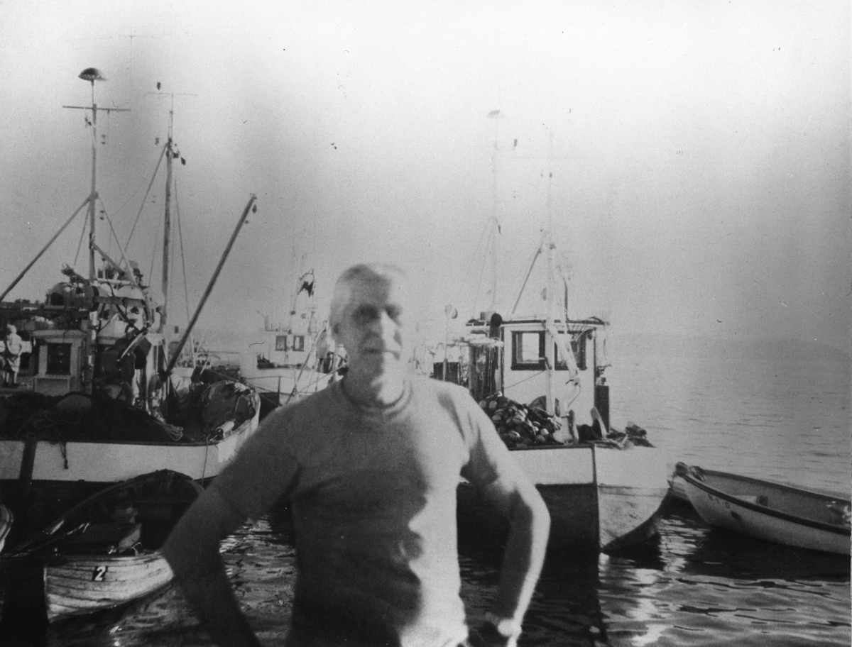 Mann på kaia med flere fiskebåter i bakgrunnen. "Johan på brygga" drev fiskemottaket i Son i en årrekke.