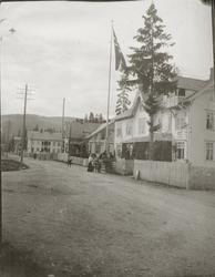 Gatebilde med flere mennesker og hest og vogn.