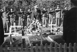 Hjemmestyrker ved et gravsted for falne under krigen. Bilde 