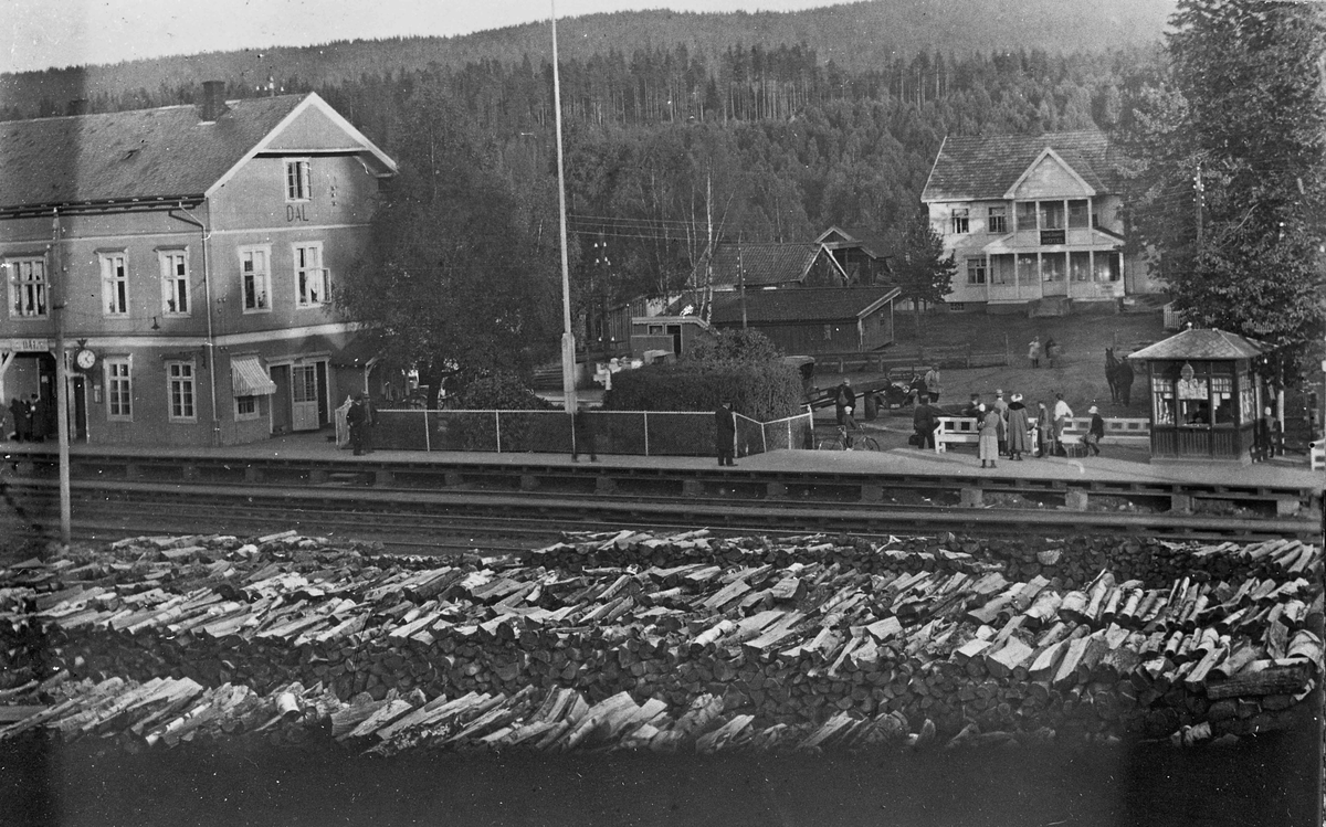 Dal stasjon, hotell, kiosk og mellomkrigsmodell biler. Mellom 1917 og 1931. Huset i bakgrunnen med verandaen er ”Dalshaugen”.