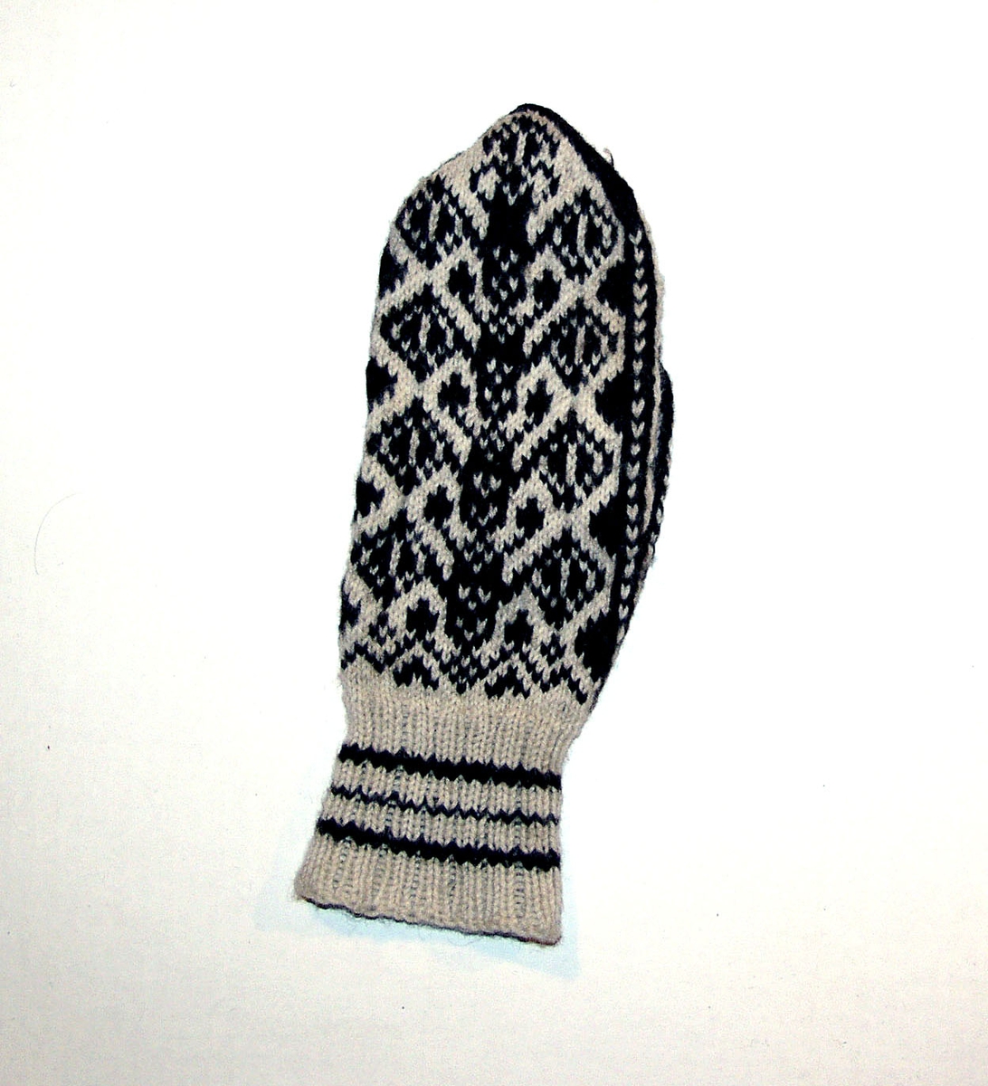 En ullvott, strikket, med mønster i hvitt og mørkt brunt.
