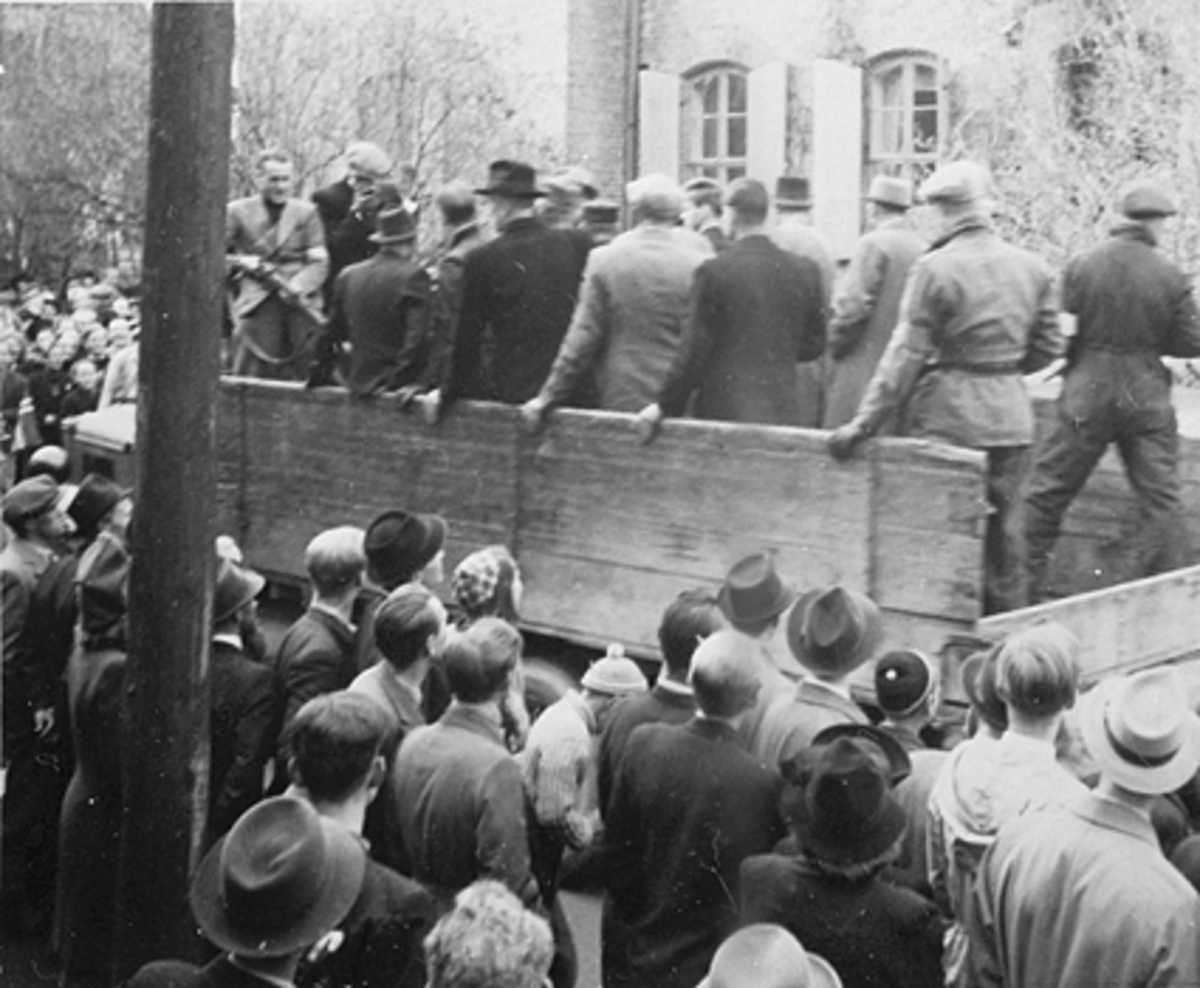 Frakting av nazister på lastebil ved Hamar kretsfengsel, mye folk. Kretsfengselet ble raskt fylt med 150 fanger mistenkt for landssvik, Frimurerlosjen ble brukt som provisorisk fengsel og huset ca 200 fanger. 