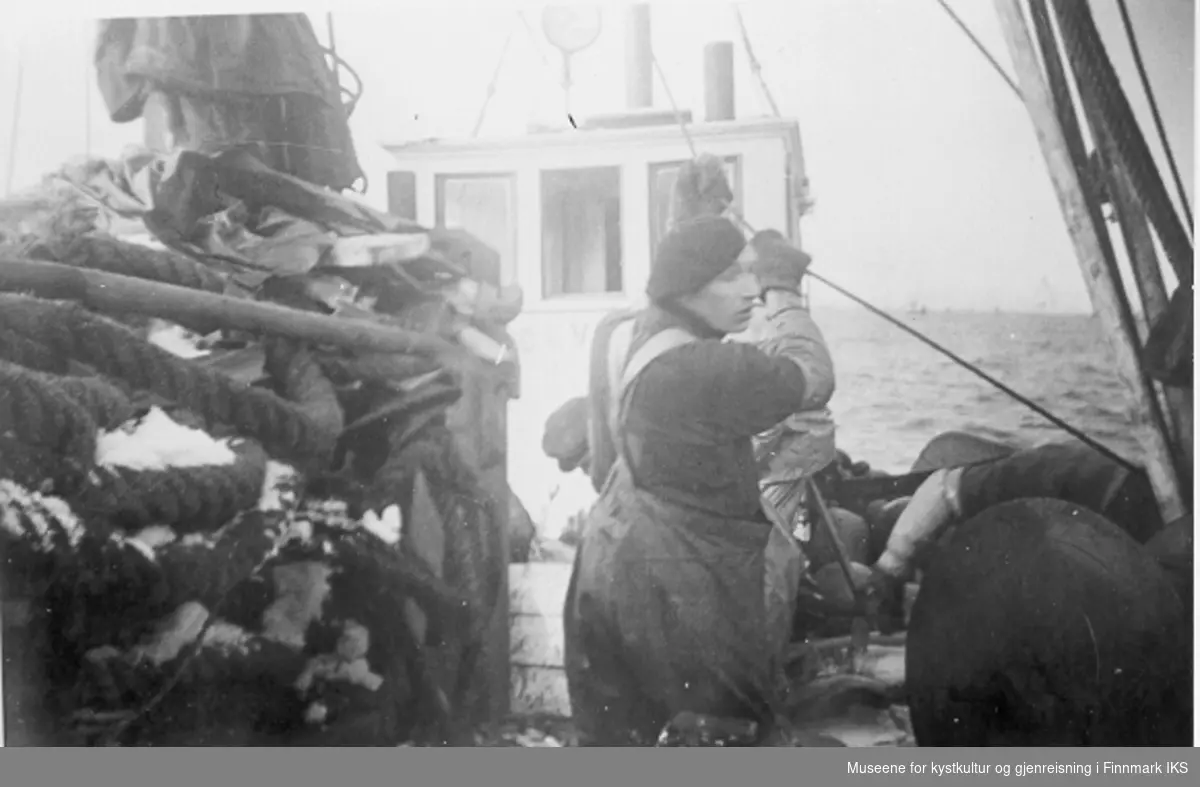 Karl Johan Olsen styrer tråltau på trommelen. Snurrevadnota skal hales ombord i Mk "Solvang" av Berlevåg. Ca 1952