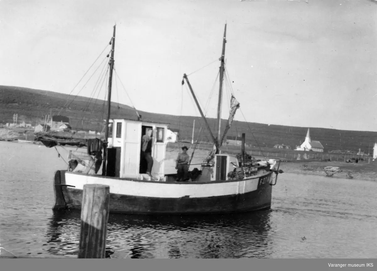 Båten Delfin i Vestre Jakobselv med Magnus Pedersen i døren og Arne Jakola på dekk med hatt.