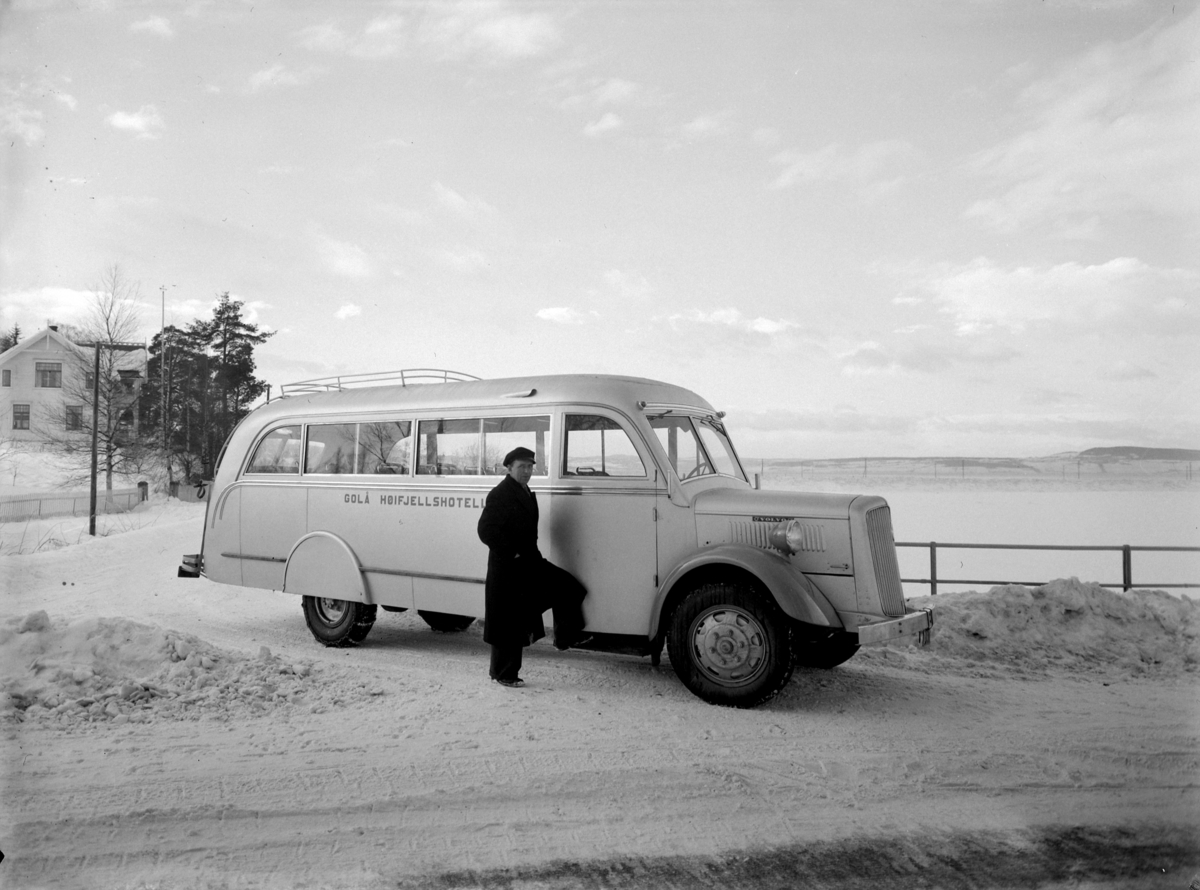 JORDKJEND, MANN + BUSS M/ "GOLÅ HØIFJELLSHOTELL"
Sjåføren er min far, Ludvig Graff fra Hundorp. 1894-1965. Han jobbet på Golå i 30-35 år. 
Bussen er en Volvo 1936. karosseriet ble laget av Kristiansand Karosserifabrikk. Den gikk i fast rute mellom Harpefoss og Golå fra ca 1936 til ca 1960. Min far hadde rutevognbevilgning på strekket. Under krigen gikk den på gengass (knott). Den ble vedlikeholdt av far og Jakop Kleiven, Otta. 
Dekkslene over bakjulene forsvant fort, og den fikk også støtfanger med plogfeste foran. 
Bildet er tatt ved Stangebrua, Hamar/Stange. 